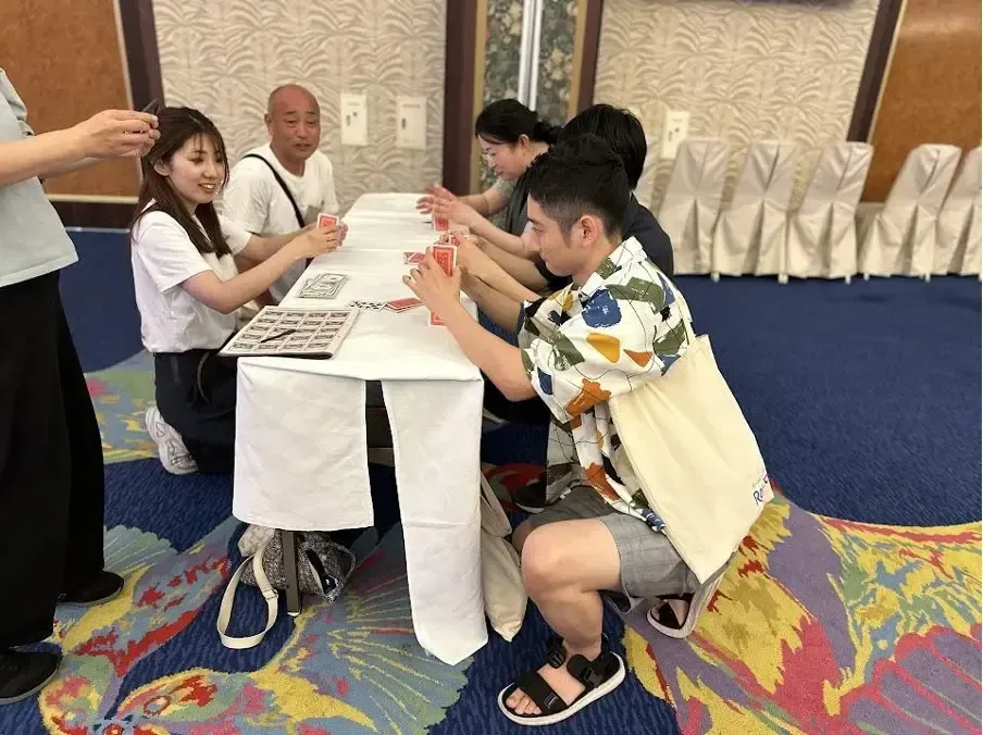 床に広げたパネルを囲んで謎解きに取り組む参加者