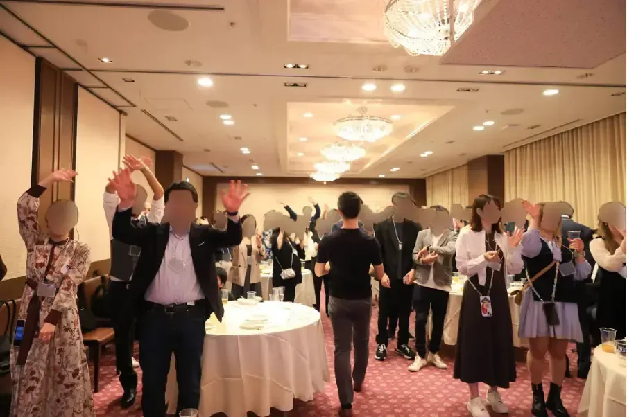 閉会の挨拶に合わせて両手を挙げる参加者の皆様