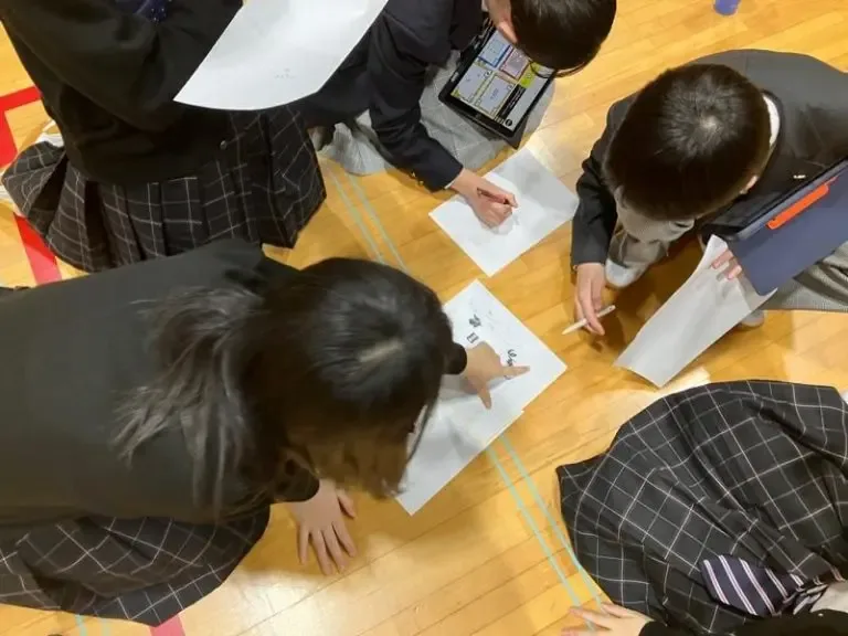 机を囲んで謎解きに取り組む参加者