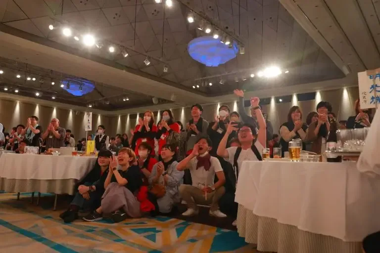 グラスを掲げて盛り上がる会場の様子